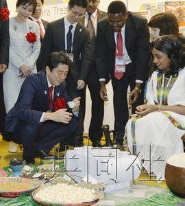 5月31日下午，日本首相安倍晋三在第五届非洲开发会议（TICAD）开幕前一天举办的“非洲物产展”上品尝埃塞俄比亚咖啡。（共同社）