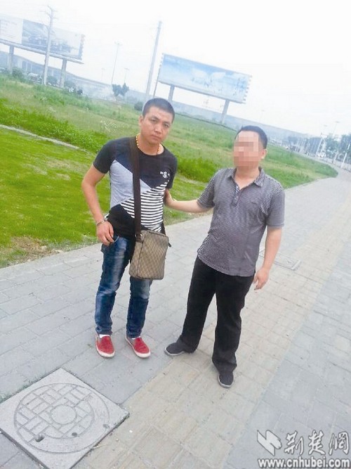 图为：便衣刑警押解嫌疑人彭红涛（左）
