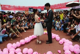 新郎胡啸宇和新娘刘庆华在足球场上深情对视。图/记者陈勇