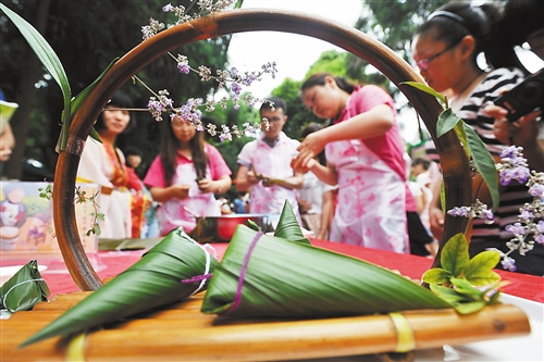 6月5日,重庆商务职业学院,同学们与老师一起进行包粽子比赛.