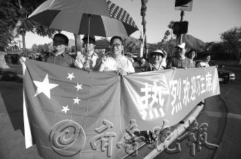 当地时间6月6日傍晚,习近平下榻的凯悦酒店旁边,当地华人举起国旗和横幅迎接。