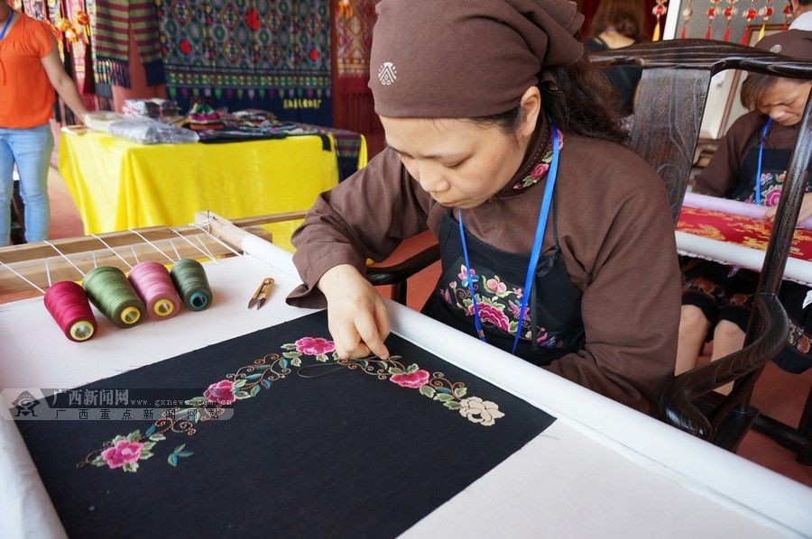 非遗手工技艺展示现场,传承人展示壮锦编织刺绣工艺技巧.