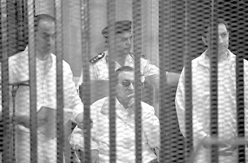 图为穆巴拉克（中）在庭审中。