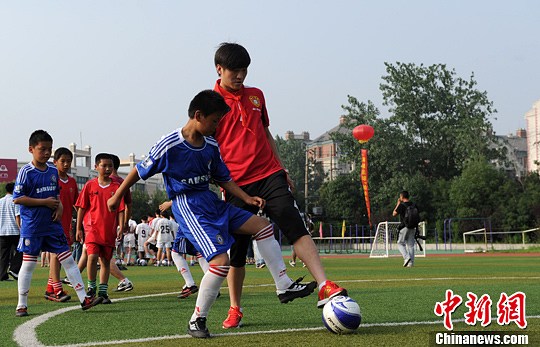 中国足球队球员吴磊给小球迷们签名留念