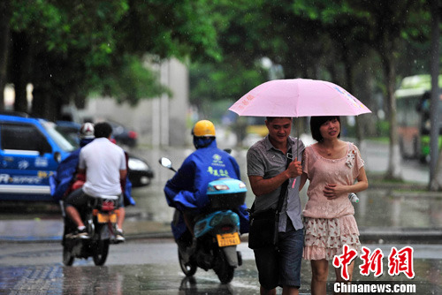 6月15日，海口市民冒雨出行，受今年首个热带低压影响，海南大部出现明显降雨天气。中新社发 骆云飞 摄