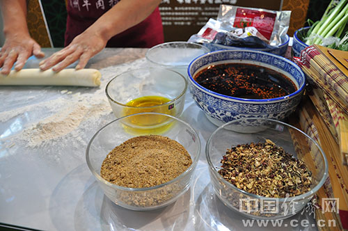 2013中国国际食品安全与创新技术展览会6月17日-19日在中国国际展览中心(三元桥)举行。兰州展台前,参展观众被牛肉面制作工艺吸引。(中国经济网徐晶慧摄)