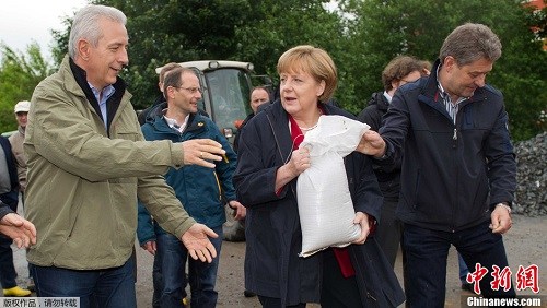 当地时间2013年6月4日，德国皮尔纳，德国总理默克尔视察洪灾区，并参与搬运沙袋。近日，持续降雨引发欧洲多国洪灾。