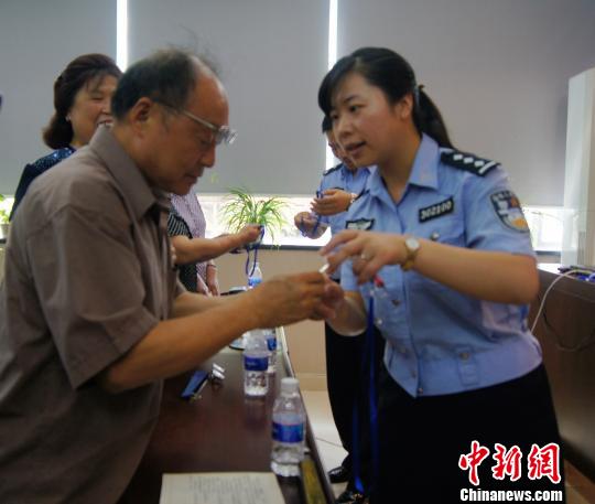 重庆民警为老人发放“爱心联系卡” 。　张燕　摄
