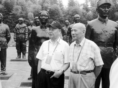 王文燮（左）和黄埔军校同学会会长林上元在抗日烈士群像前合影。