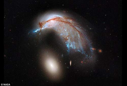美国宇航局哈勃太空望远镜最近拍下了两个星系相撞的图片。这张图片看上去就像是一只企鹅正在玩耍一枚蛋。