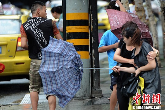 图为市民打着雨伞被大风吹翻.陈超 摄
