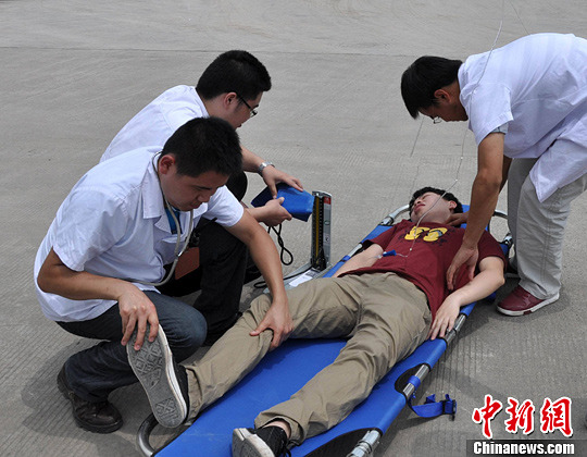 6月26日，重庆消防官兵和消防医院等人员组成应急救援队，联合开展7.0级地震救援拉练演习。图为救出“伤员”。中新社发 王刚 摄