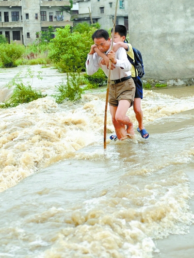 村民背着学生涉水过河(图)