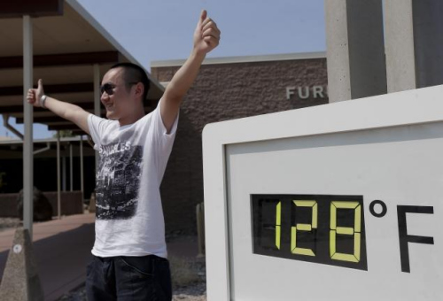 图为美国加州死谷温度达到华氏128度约53摄氏度时，人们和温度计合影。