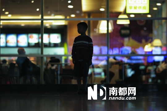 北京南站的一间快餐店门前，已跟着爸爸上访4年的李浩然(化名)显得很茫然。 南都记者 贺顿 摄