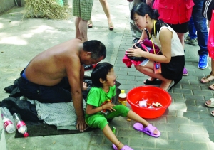 记者找到小女孩时，男子正带着她在中央路上乞讨 现代快报记者 施向辉 摄
