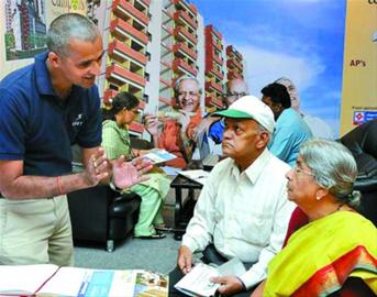 销售人员正在向印度老年人推介老年公寓