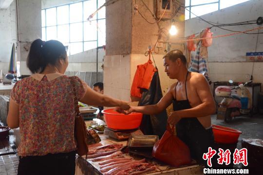 7月8日，市民在广西贺州市城西农贸市场买鱼。 唐梦宪 摄