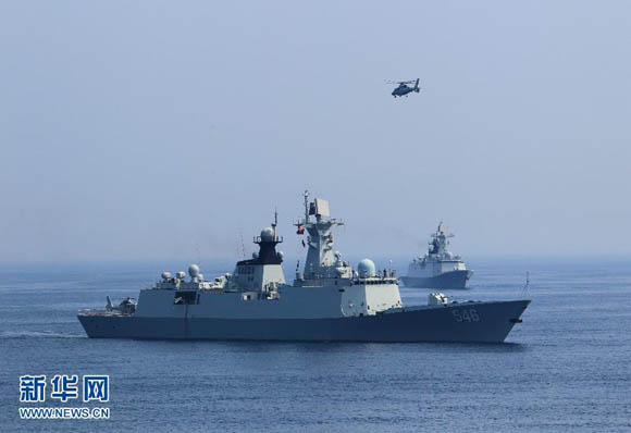 资料图：2013年7月9日，在“海上联合—2013”中俄海上联演中，中国海军军舰和舰载直升机参加实兵演练。