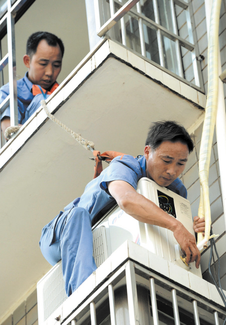 昨日,两名空调安装工人冒着酷暑为客户安装外机.