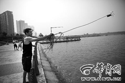 昨日，灞河岸边，刘有仁演示如何用绳钩打捞溺亡者 本组图片由本报记者 袁琛 摄