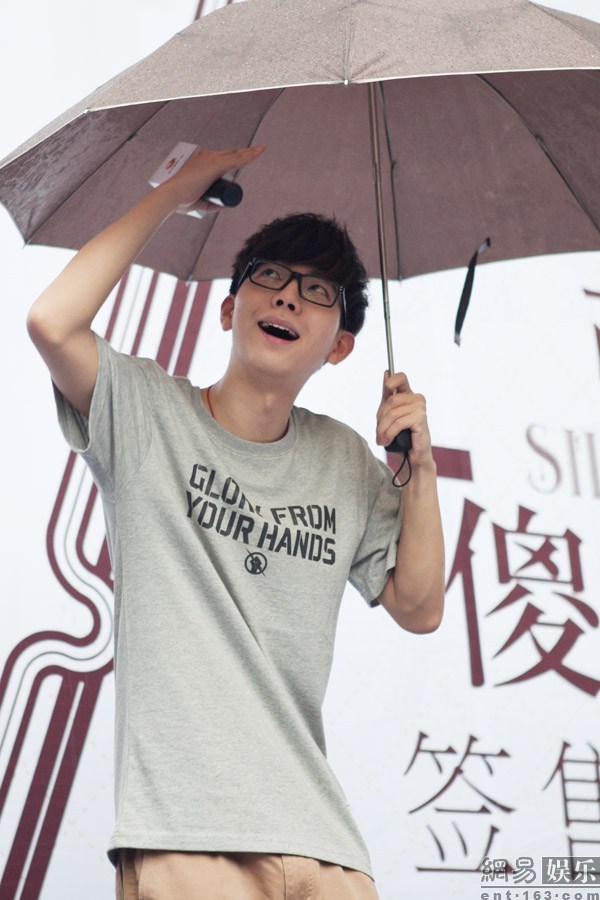 胡夏冒雨宣传新专辑 甩雨伞湿身与粉丝玩合影