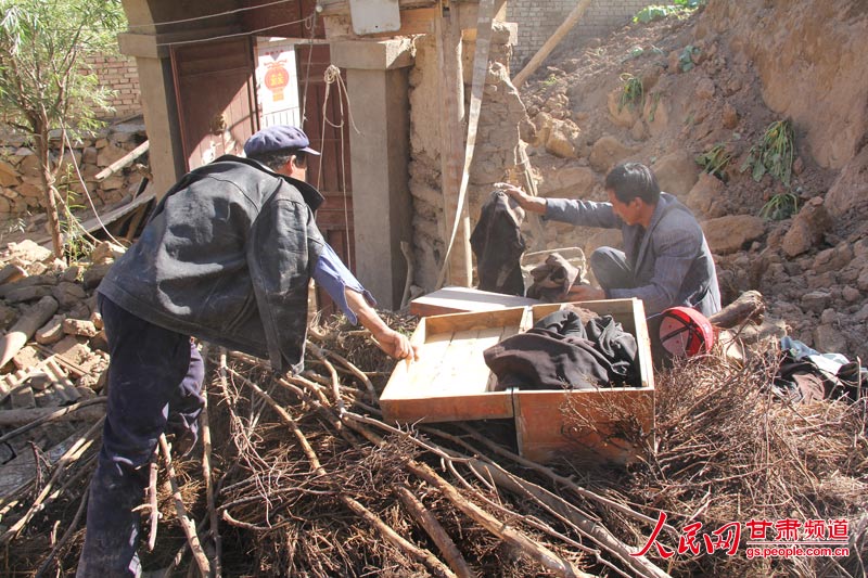 董寿平正在整理已在地震中死去老母亲的遗物.(王生元 摄)