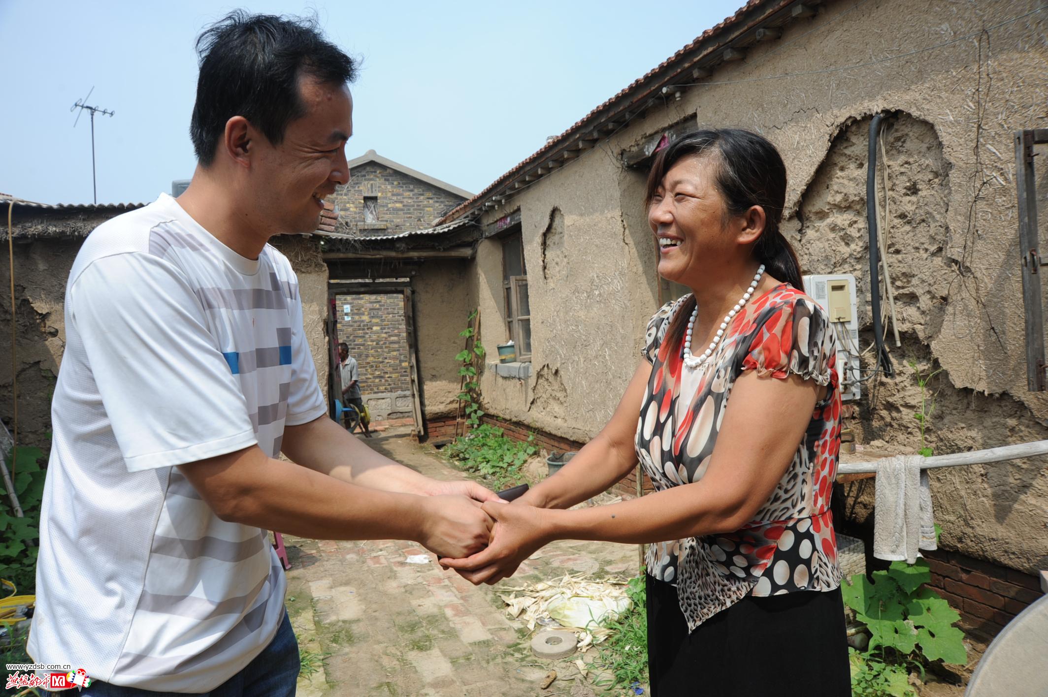 杨老师紧紧握住李桂芹的手,感动得直说她人好.通讯员王乾/摄