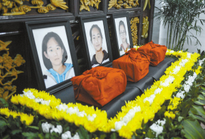 江山市殡仪馆守灵室内3名遇难女学生的骨灰和遗像(7月29日摄)