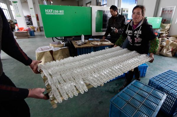 一名工人搬运生产中的情趣用品.喇叭裤情趣皮图片