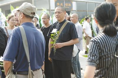 陈丹青手持白花也来送别朱乃正。 新京报记者 秦斌 摄