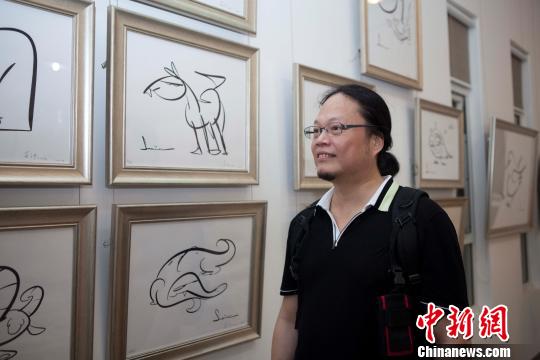 台湾漫画家萧言中首次以平板电脑即兴创作的漫画作品在北京万荷艺术园区展出。 路梅 摄