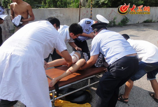 民警和医务人员将伤者抬上担架,送至医院救治.