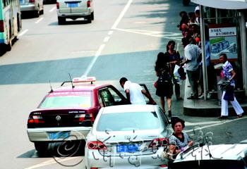 15日,南大街市长大厦附近,一辆出租车在行车道上急停上下客.
