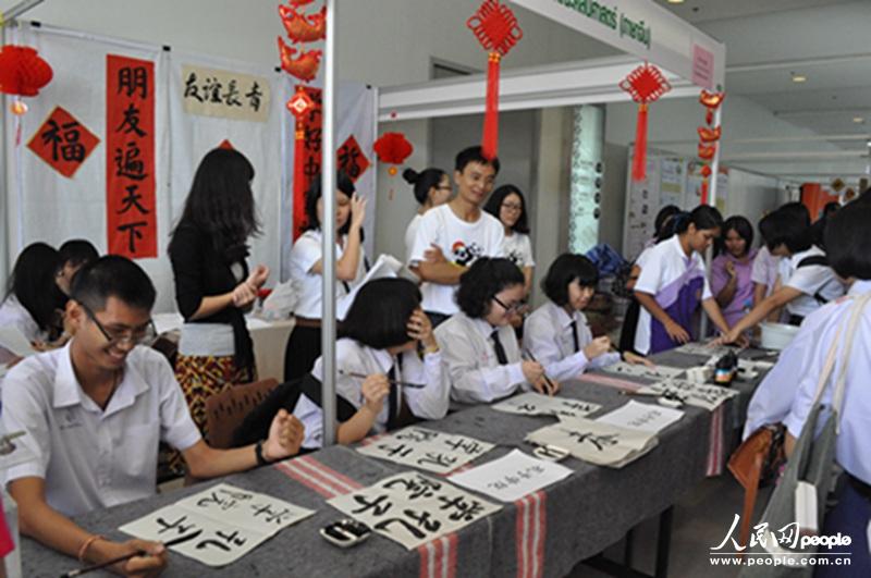 图为中学生们在参加书法小竞赛