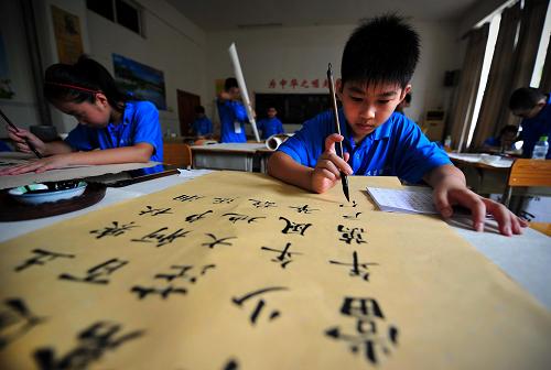 8月19日,参加第五届全国青少年书画大赛的小选手参加毛笔书法比赛.