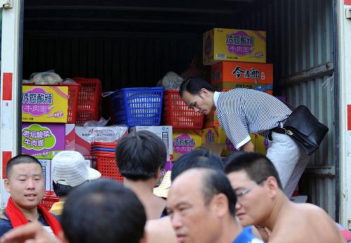 8月20日，在广西武（宣）平（南）公路，当地政府组织的人员给翻山越岭走出来的部分被困司机发放食物。新华社记者 周华 摄