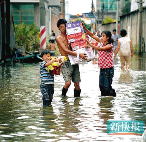 昨日，潮南区司马浦镇港西村，水位退了不少，救济品也来到村里。一家三口领了食物，孩子也帮父母把物品抱回家。