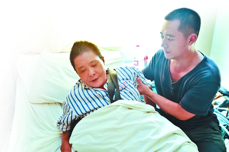 昨日，九龙坡区第一人民医院，韩信正照顾病重的母亲。 记者 张路桥 实习生 程雯丽 摄