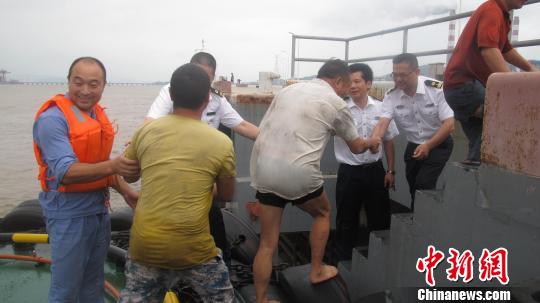 图为几名落水船员被安全送到岸上。 吴樟强 摄