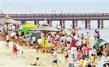 图 8月24日,游客在北戴河浅水湾浴场玩耍。