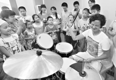 孩子们在老师指导下学习打架子鼓