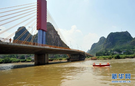 新8月28日,在广西贺州市八步区贺江灵峰大桥下,救援人员乘坐冲锋舟在
