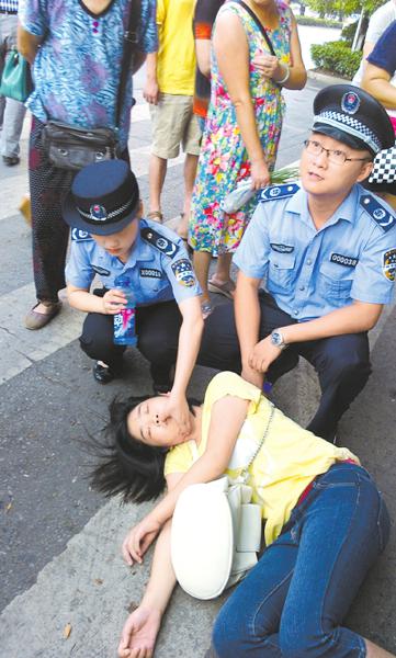 广安:女孩晕倒遭围观 全靠城管救起来(图)两名城管队对晕倒的女孩施救