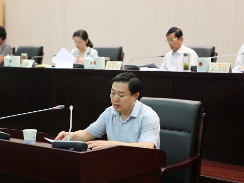 图为市政府副秘书长谢建林作关于惠农政策落实情况的报告