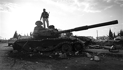9月8日,叙利亚Zabadani,一名叙利亚反对派武装人员站在废弃的政府军坦克上。