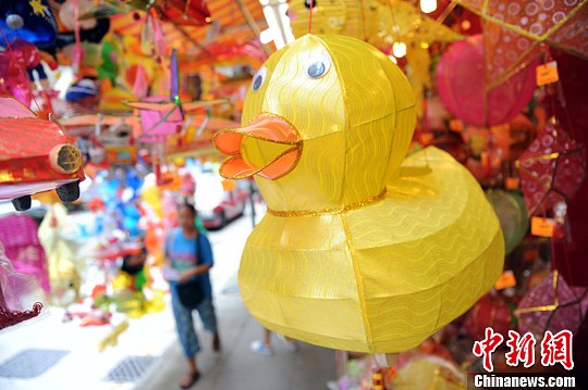 9月13日，位于香港商铺门外挂满各式灯笼，当中最瞩目的是黄鸭。黄色巨鸭早前畅游维港，风靡全城，今个中秋黄鸭化身灯笼主角。中新社发 谭达明 摄