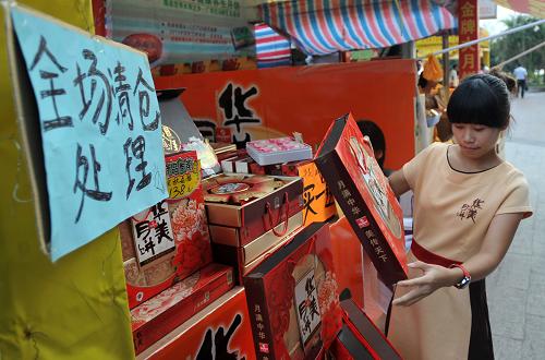 9月17日，在广西南宁市仙葫大道，一名月饼销售商在展示简朴包装月饼的价格。新华社记者 陆波岸 摄