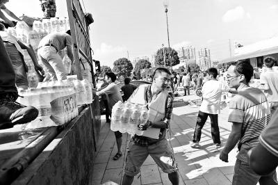 10日，在余姚市一处救灾物资集散点，来自宁波市区的志愿者正有秩序地搬运救灾物资
