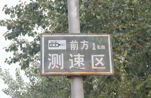 该路段前方一公里有测速区,据记者当地勘测此警示牌后就是村庄而一